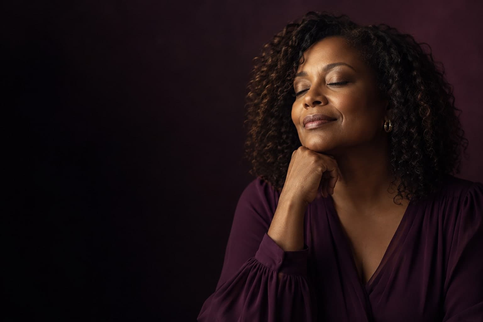 An adult woman enjoying a quiet reflective moment in warm light.